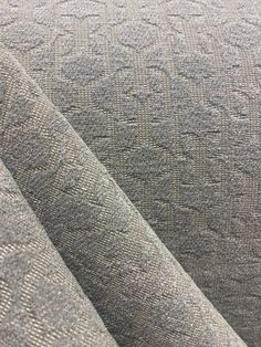 an upholstered fabric textured with grey and white patterns, closeup view