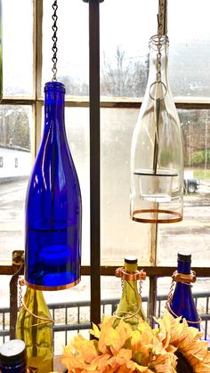 three vases with flowers in them sitting on a window sill