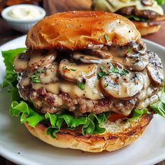 a mushroom burger with lettuce and mushrooms on a bun sitting on a plate