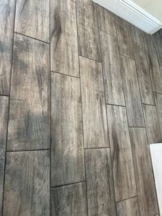 a bathroom with wood flooring and tile on the walls is shown in this image