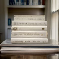 a stack of books sitting on top of a wooden table