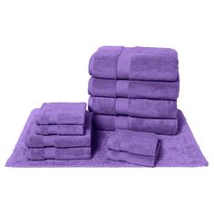 a pile of purple towels sitting on top of a rug