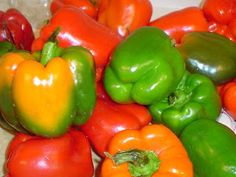 a pile of red, green and yellow peppers