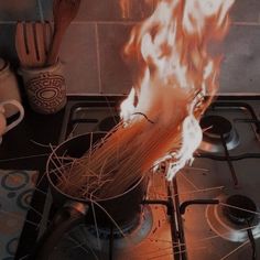 a stove top that has some kind of fire coming out of the pot on it