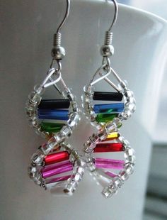 a pair of colorful earrings sitting on top of a white cup