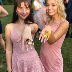 two girls in pink dresses pointing at the camera