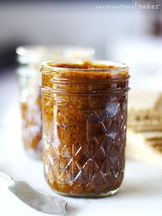 two jars filled with food sitting on top of a table