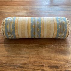 a rolled up pillow sitting on top of a wooden floor