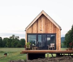 a small wooden house sitting on top of a lush green field