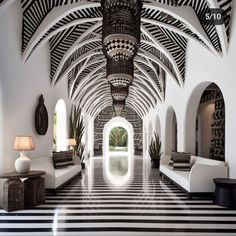 a long hallway with black and white striped flooring next to two large couches