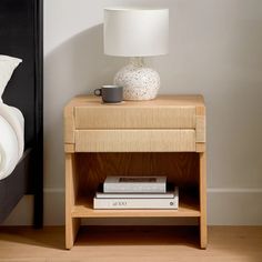 a nightstand with books and a lamp on it