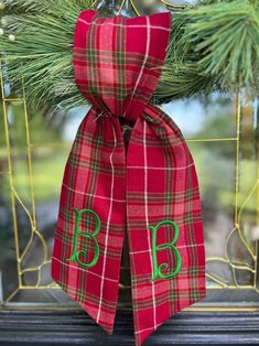 the monogrammed bow is hanging on the mantle in front of the christmas tree