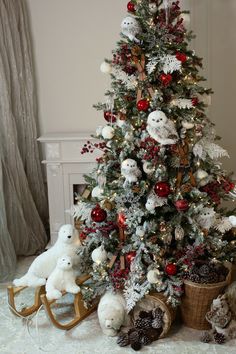 a decorated christmas tree with red and white ornaments in a basket next to two teddy bears