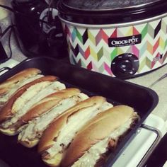 there are many sandwiches in the pans on the counter next to the crock pot