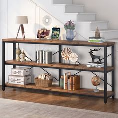 a book shelf with books and other items on it in front of a stair case