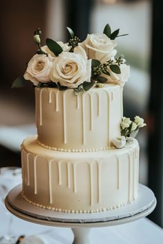 a three tiered cake with white flowers on top