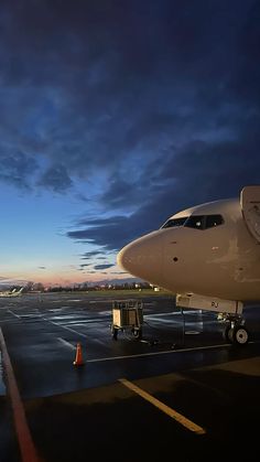 an airplane sitting on the tarmac at dusk