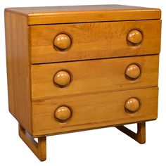 a wooden dresser with two drawers and three knobs on the front, one drawer open