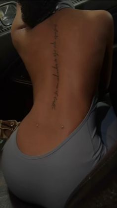 the back of a woman's body with writing on it