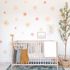 a baby's room with a crib and wall decals