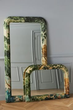 two mirrors sitting next to each other on top of a wooden floor in front of a wall