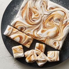 some kind of dessert on a plate with icing and powder sprinkles