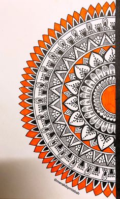 an orange and white drawing on a piece of paper next to a black marker pen