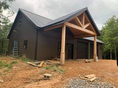 a large brown building sitting on top of a dirt field next to trees and rocks