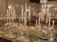 a table is set with candles and flowers for a formal dinner or reception in a fancy setting