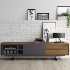 a living room with white brick walls and wooden furniture in the center, along with pictures on the wall