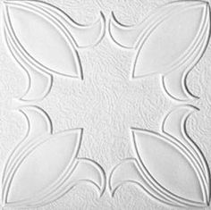 a white ceiling tile with leaves and circles in the center, on top of a wall