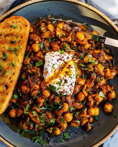 a plate with bread, eggs and chickpeas on it next to a fork