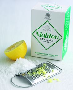 a box of maldon sea salt next to a grater and lemon wedges