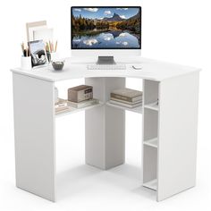 a white desk with a computer monitor and keyboard on it, next to other office supplies