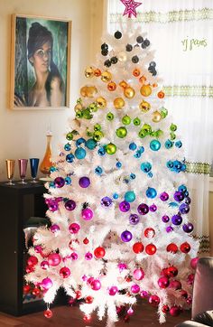 a white christmas tree decorated with colorful ornaments