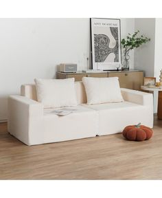 a white couch sitting on top of a hard wood floor next to a wooden table