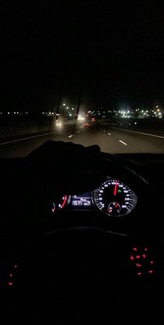 the dashboard of a car at night with its lights on and it's speedometer lit up