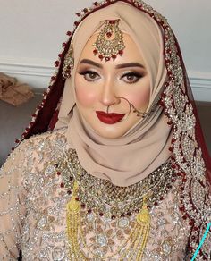 a woman wearing a hijab and makeup looks at the camera