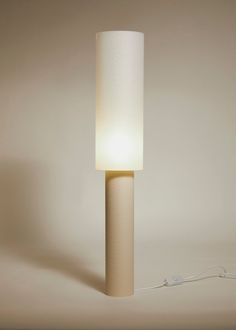 a lamp that is on top of a white table cloth with a cord attached to it