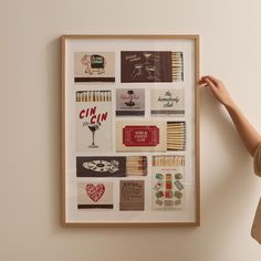 a woman is holding up a framed art piece with matches and matchsticks on it