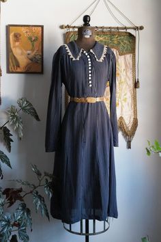 "Vintage 1930s navy blue pin striped soft cotton handmade dress. Decorative white buttons up the front with snap button closures. Slips on overhead. Ecru cream lace around collar. Sleeves are a bit small, so please refer to armscye measurement. Condition: good vintage condition. Some pinholes throughout. Measurements are taken with item lying flat. Shoulders: 15\" Bust: 20 Waist: 19 Hips: 22\" Sleeves: 23\" Armscye: 9\" Length: 42.5\"" Navy Vintage Dress With Buttons, Navy Vintage Dresses With Buttons, Vintage Long Sleeve Striped Dresses, Vintage Striped Dresses For Daywear, Robert Ryan, Sequin Ball Gown, 1930s Dress, Pinstripe Dress, Ball Gown Skirt