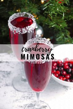 two glasses filled with cranberry mimos sitting on top of a table