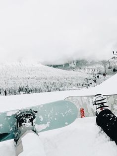 two snowboarders with their feet propped up in the snow