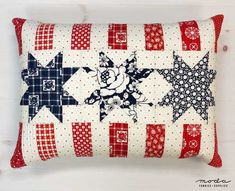 a red, white and blue quilted pillow with stars on it's side