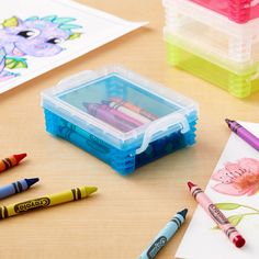 some crayons are sitting on a table next to colored pencils and markers