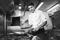 black and white photograph of a man cooking in a kitchen