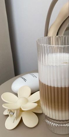 a glass with some food in it next to a flower