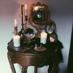 an ornate table with candles and mirrors on it