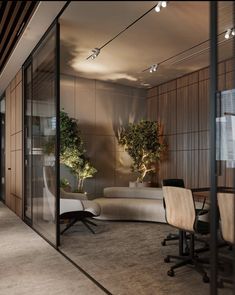 an office with glass walls and plants on the wall, along with two chairs that are facing each other