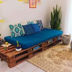 a couch made out of wooden pallets in a living room next to a rug